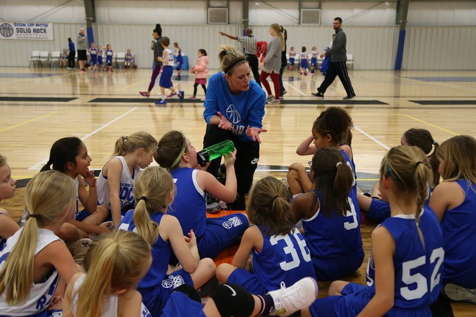 basketball coach with players on court