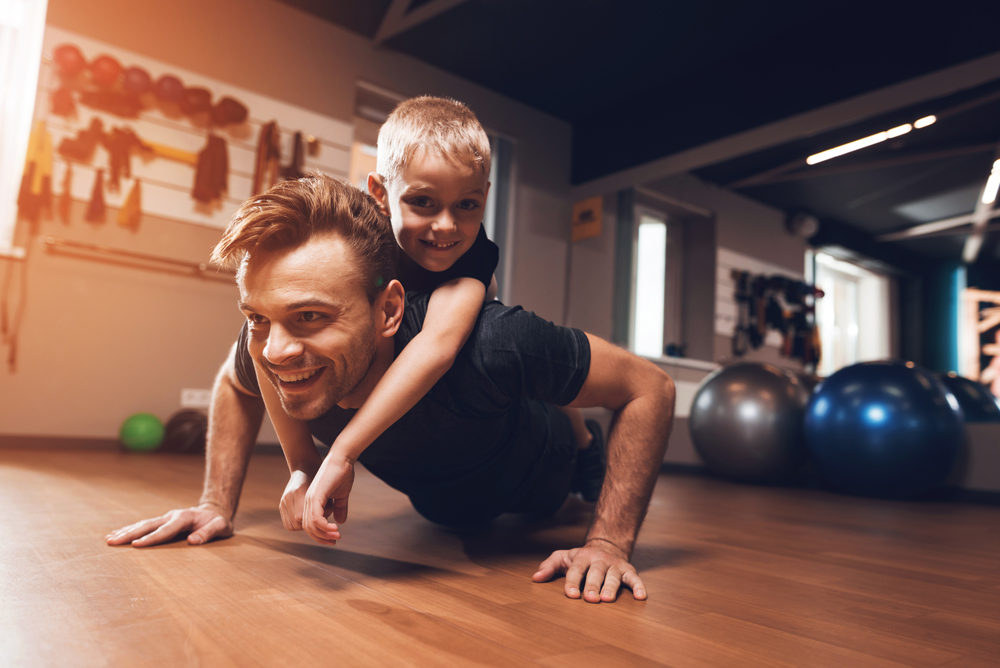 father son exercising on sports floor